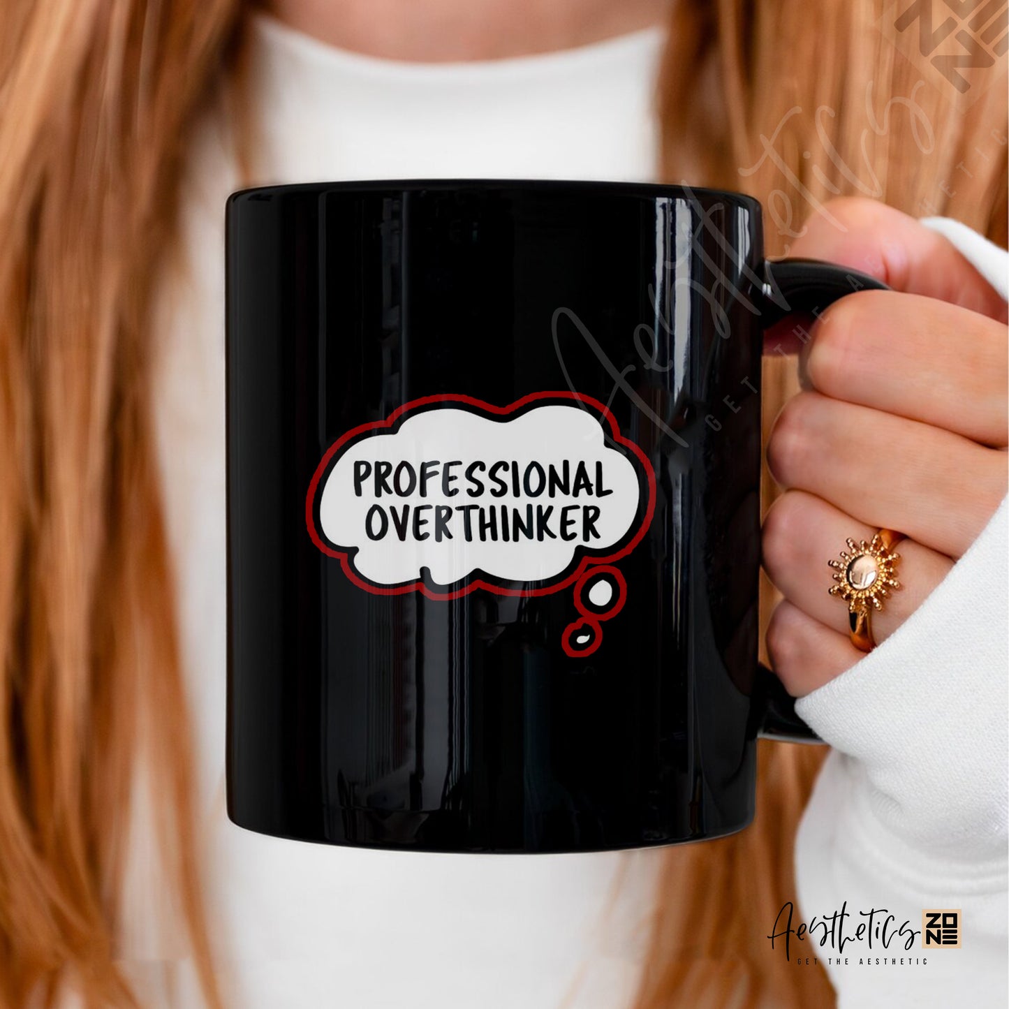 Black mug with 'Professional Overthinker' text held by a person with red hair.