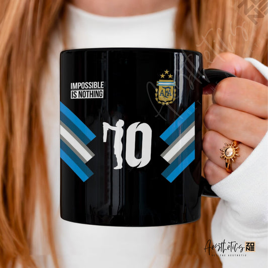 Black mug with sports team logo and text held by a person