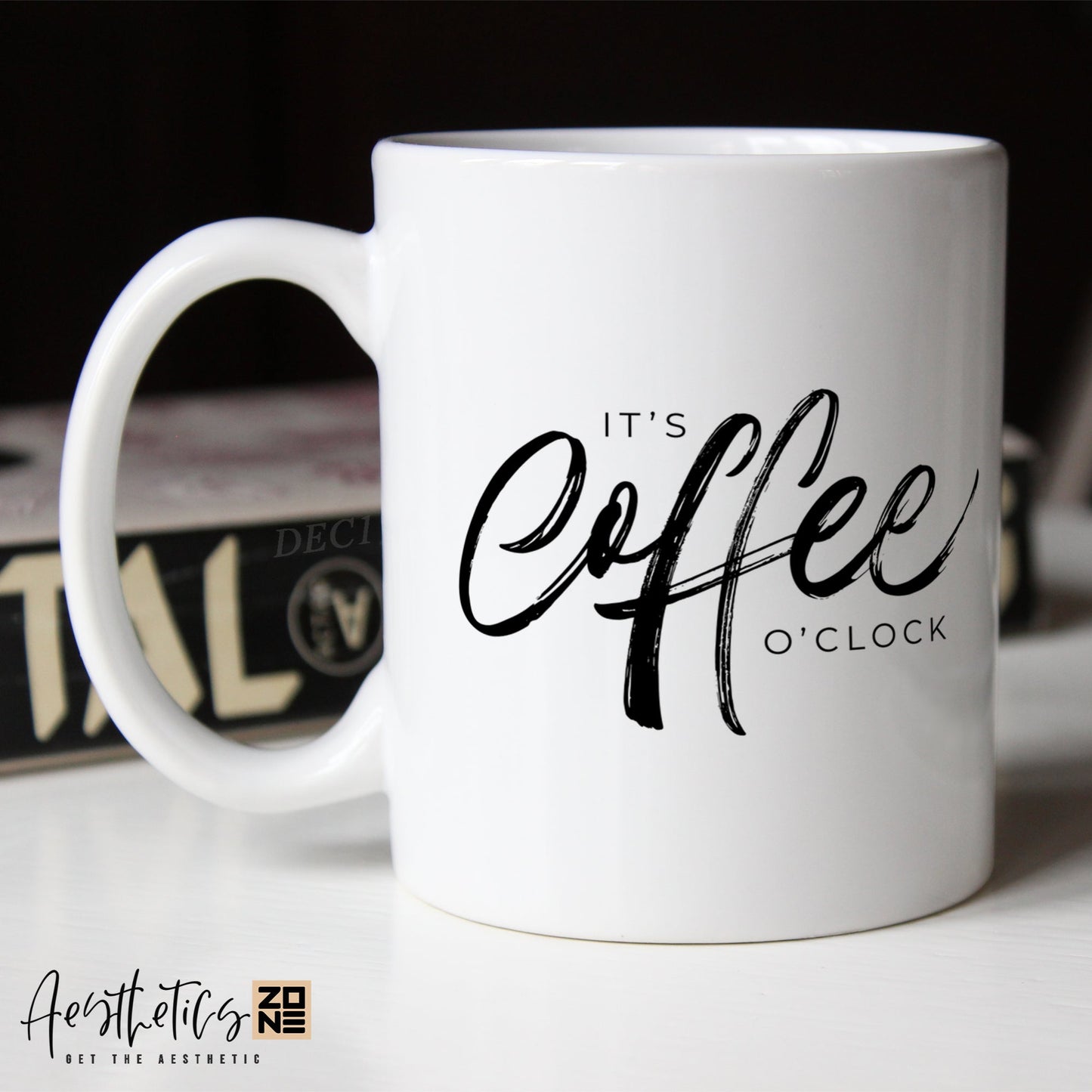 White coffee mug with 'It's Coffee O'Clock' text on a blurred background