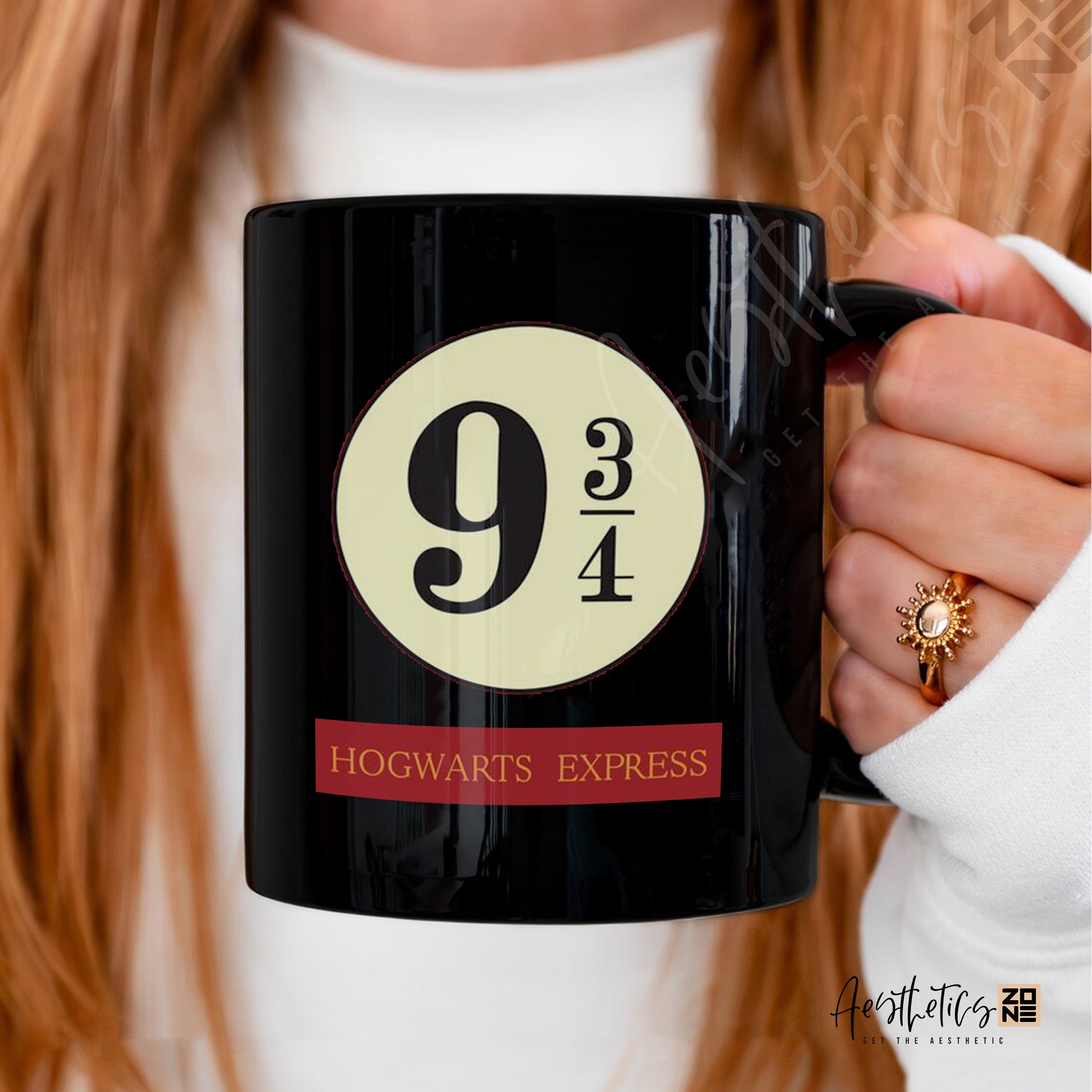 Black mug with 'Hogwarts Express' design held by a person with red hair.