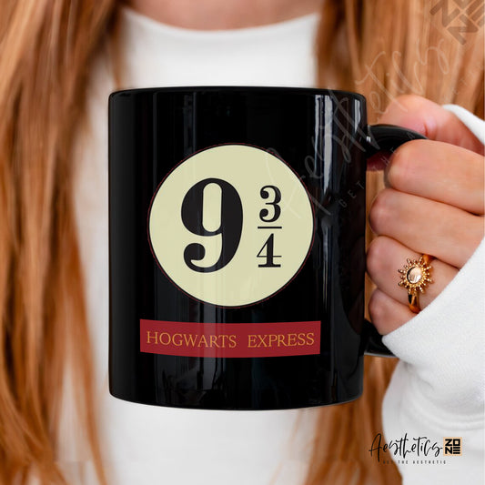 Black mug with 'Hogwarts Express' design held by a person with red hair.