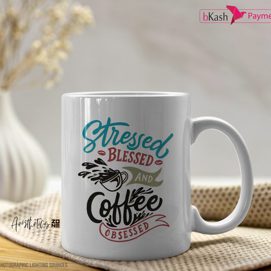 White mug with colorful text on a wooden surface with a blurred background