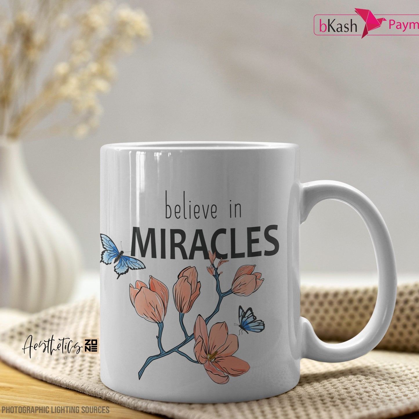 White mug with 'believe in miracles' text and floral design on a table.