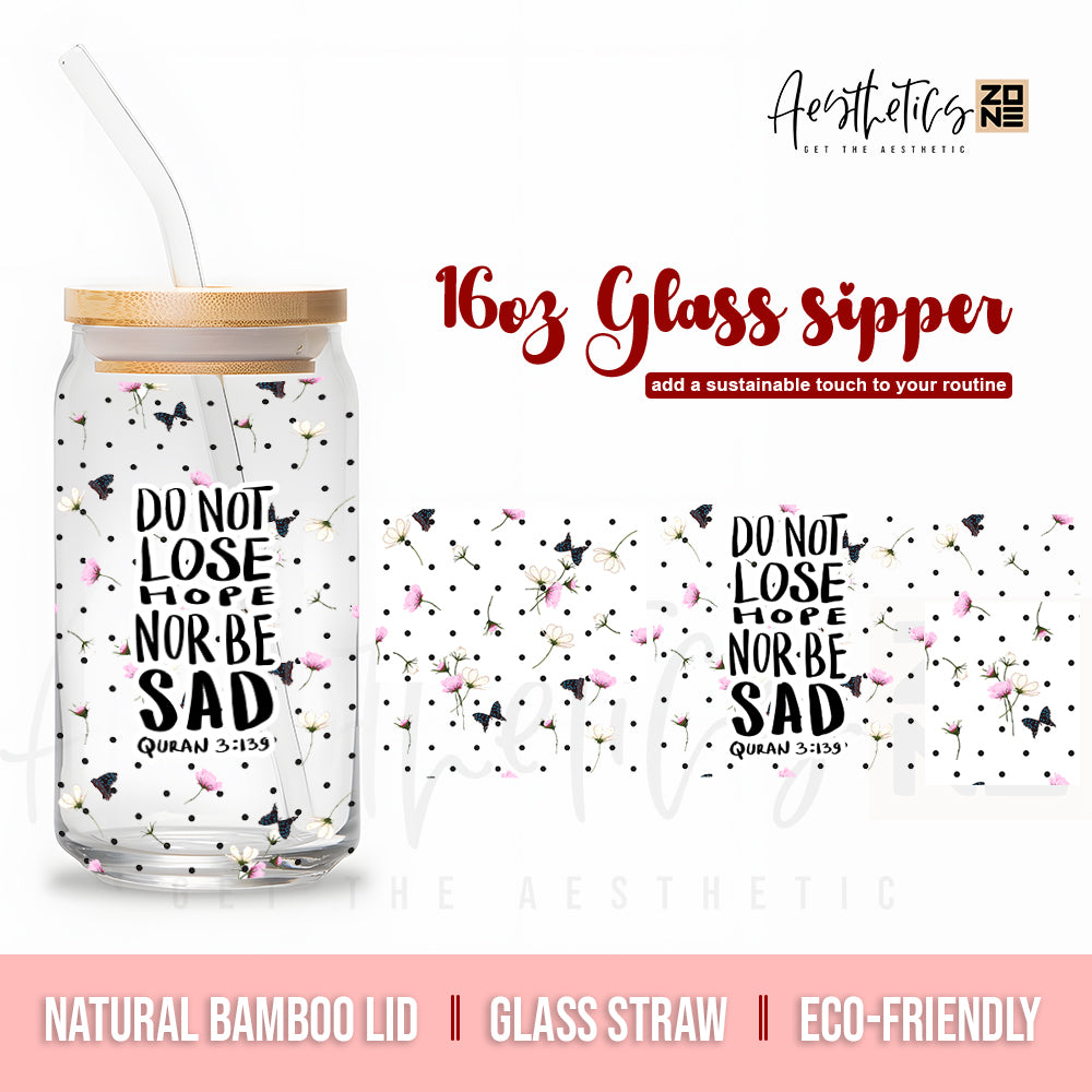 Glass sipper with motivational quote and bamboo lid on a white background