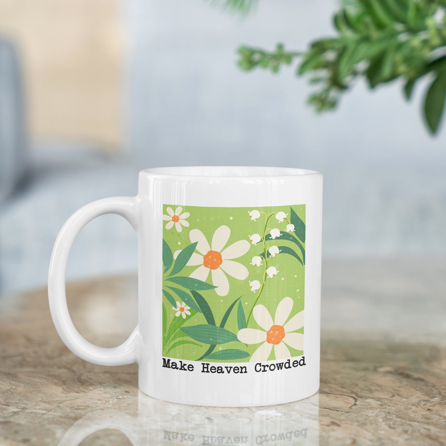 White mug with floral design and text on a wooden surface with a blurred background