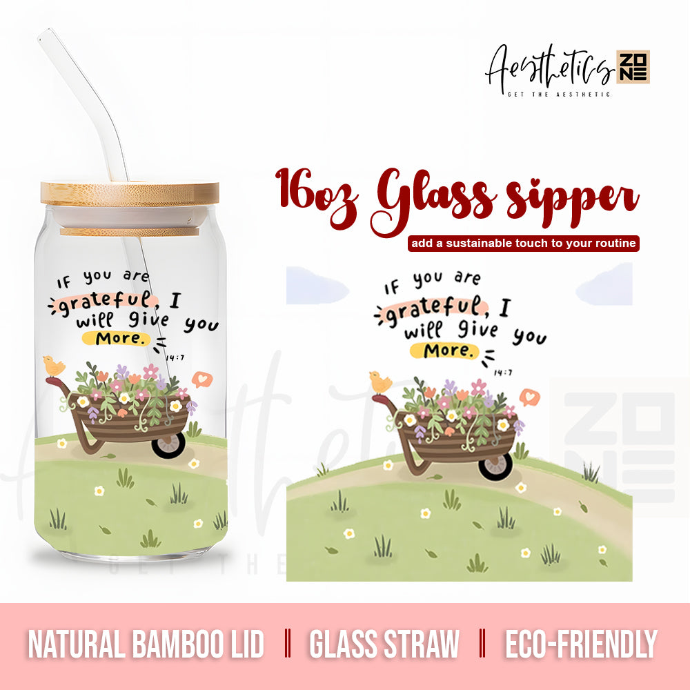 Glass sipper with bamboo lid and glass straw, featuring a garden design and motivational quote.