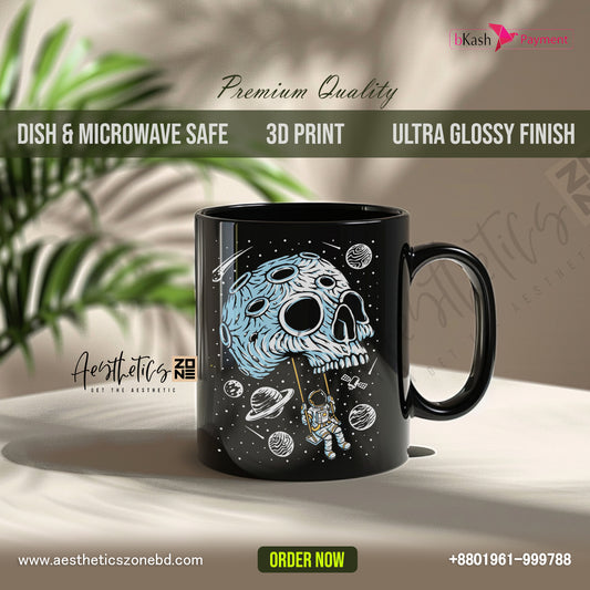 Black mug with space-themed design on a light surface with plants in the background