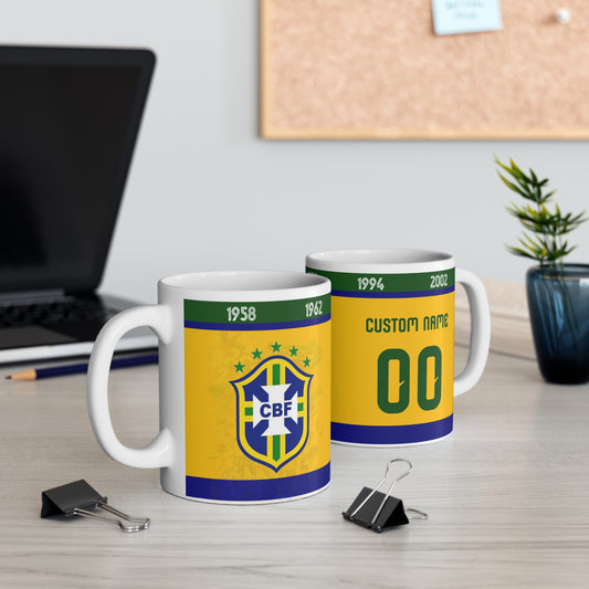 Two mugs with Brazilian flag design on a desk with office items.