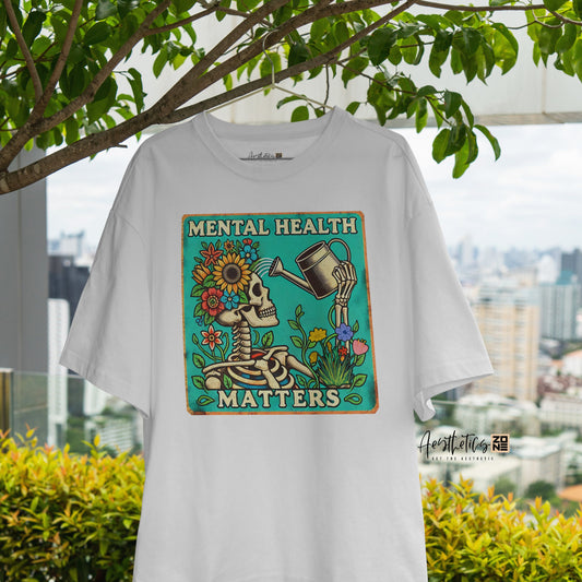 White t-shirt with 'Mental Health Matters' design hanging outdoors with greenery and cityscape in the background
